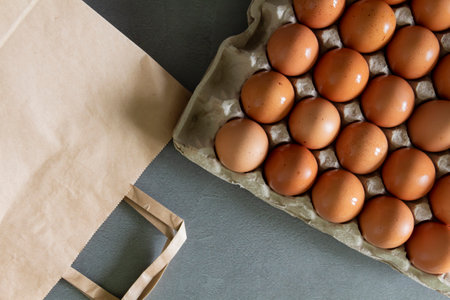 Chicken eggs lie in a tray on the kitchen surface with a paper bag. Buying products and goods in the storeの写真素材