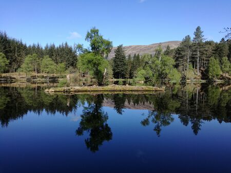 Wonderful lake with reflection of tiny islandの写真素材