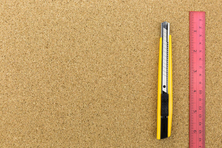 cutter and red ruler on the cork board with spaceの写真素材