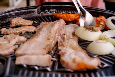 Selective focused Samgyeopsal or Korean BBQ , pork belly on grilling pan.
