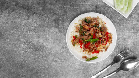 Topview Rice topped with stir-fried beef and holy basil on the gray concrete table with copy space.の写真素材