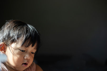 Boy face is completely covered by messy hair uncombed after play.の写真素材