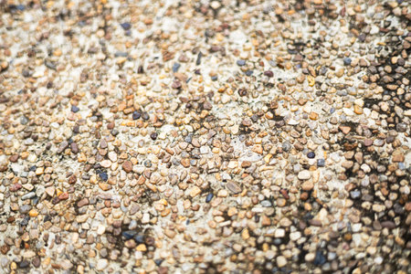 Wall texture with pieces of exposed round small stones. Concrete wall in stone chips.の写真素材