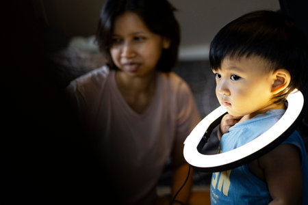 Mom And Toddler Plays With A Ring Light On His Neck.