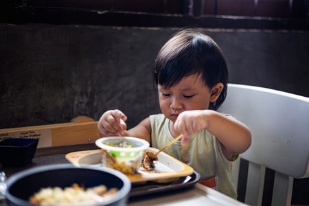 Toddler Is Eating Breakfast By Himself, Background for advertising and wallpaper in food and lifestyle scene.の写真素材