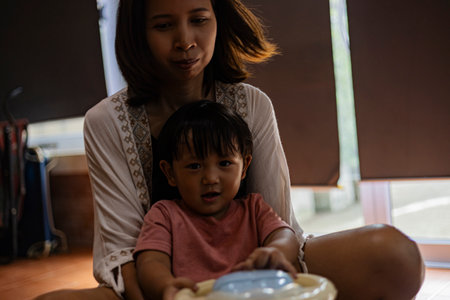 Mother And Toddler Riding A Toy Car In The House, Background for advertising and wallpaper in education and lifestyle scene.の写真素材