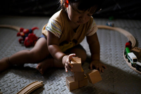 Toddler Playing With Wooden Toys, A joyful toddler stacks wooden toys, tiny hands exploring shapes in warm light, perfect for a family photography shot or a playful childhood showcase.の写真素材