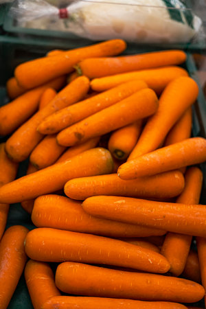 Crisp carrots fill a woven basket, their rich hues shining in natural light, ideal for a culinary photo capture or a harvest bounty display.の写真素材