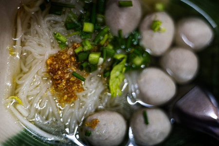 Hot Beef Meatball Noodle Soup Bowl, A dramatic ad photo of steaming beef meatball noodle soup, rich...