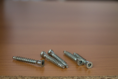 hexahedron and screws in a wooden brown boardの写真素材