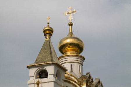orthodox cathedral on a sunny summer day with green grass in front of it and the blue cloudy sky on...