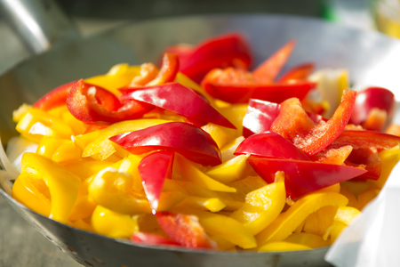 red and yellow bulgarian pepper pieces in a plate prepared for cookingの写真素材