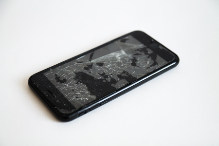 broken black smart phone with cracks on the screenの写真素材