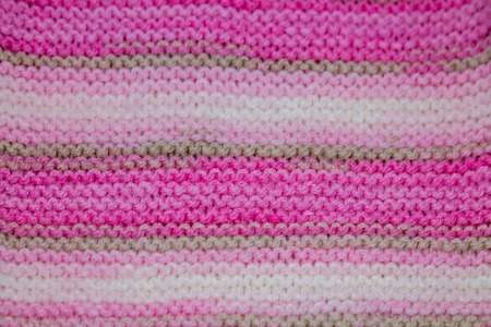 Pink, white and light brown striped knitted texture backgroundの写真素材