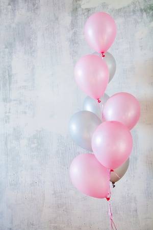 Bunch of pink and gray balloons for birthday party on gray concret background with a copy spaceの写真素材