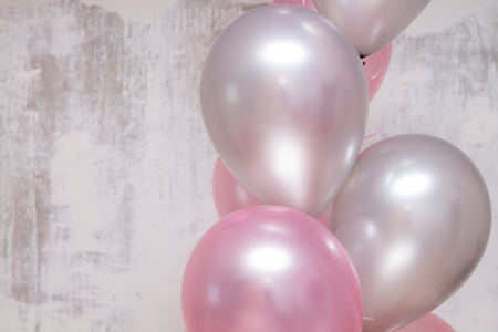 a bunch of silver and pink baloons on gray concrete backgroundの写真素材