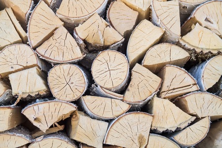 The background of chopped, sawn and stabbed stacked wooden white birch logs.の写真素材