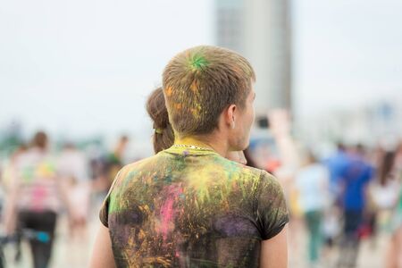 people shot from the back side with their colorful clothes stained with holi colors on Holi Festival, Festival of Colorsの写真素材