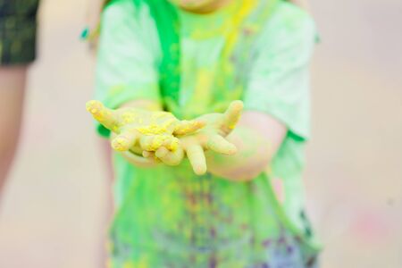 Hands, Palms of small children covered in green, yellow Holi festival colorsの写真素材