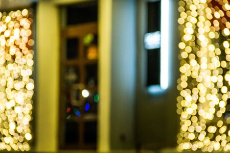 Blurred defocused entrance of cafe with boke lights at nightの写真素材
