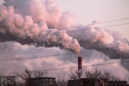 industrial chimneys with heavy smoke causing air pollution as an ecological problem on the pink...