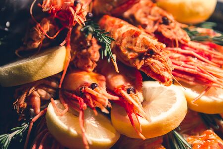 bunch of big cooked red shrimps , king prawns, crab legs, lemons and rosemary branches made as a healthy food gift full of proteinの写真素材