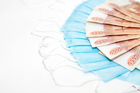 russian rubles banknotes lay on blue medical masks on white background as expenses concept during the coronavirus covid19 pandemicの写真素材