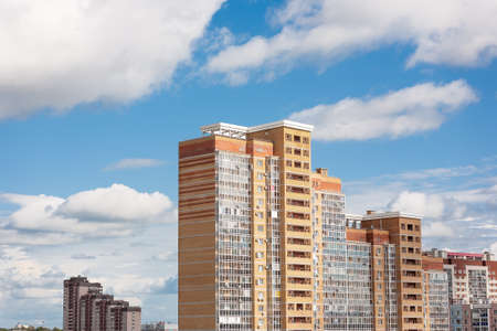 New block of modern apartments with balconies and blue sky with white fluffy clouds in the backgroundの写真素材