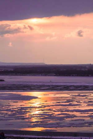 Vertical very peri view of frozen river during cold winter sunsetの写真素材
