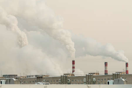 industrial chimneys with heavy white smoke causing air pollution problemの写真素材