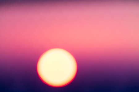 Blurred magenta and purple colored sunset through metal barsの写真素材