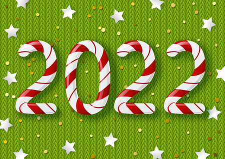 New Year concept - 2022 candy numbers on green knitted background with golden confetti and stars for winter holidays designの写真素材