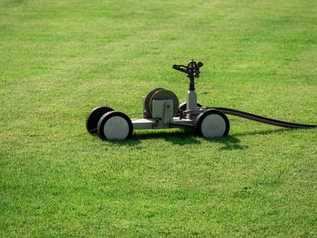 Mobile sprinkler on an empty soccer field on the countryside in the dry summer timeの写真素材