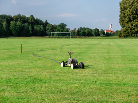 Mobile sprinkler on an empty soccer field on the countryside in the dry summer timeの写真素材