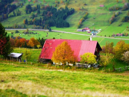 Tilt shift picture of a house with red roof on a hillの写真素材