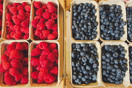 top down view on boxes of red raspbeeries and blue bluebeeriesの写真素材