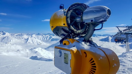 Image of an orange snow cannon in the alpsの写真素材