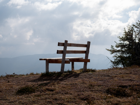 Close up image with focus of bench with mountains in the backgroundの写真素材