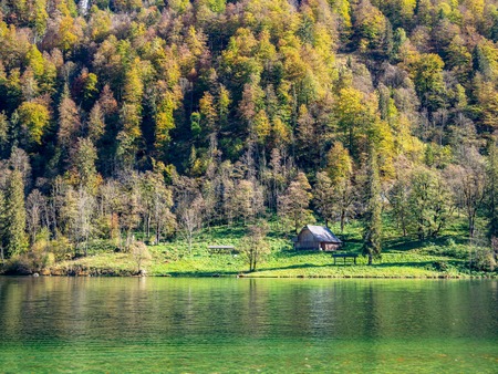 Image of little house next to a lake and forrest in autumnの写真素材