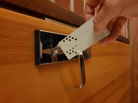 Close up Image of analog punchcard as a key to open hotel room door