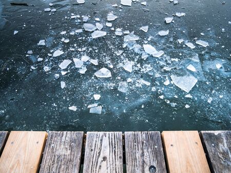 Image of crushed ice on frozen lake and taken from the edge of wooden planks. top down viewの写真素材
