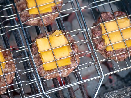 Image of bbq burger patties with cheese on grillの写真素材