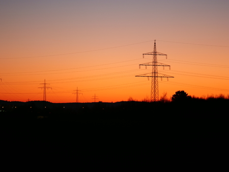 Image of power pylons in the landscape during colorful sunsetの写真素材