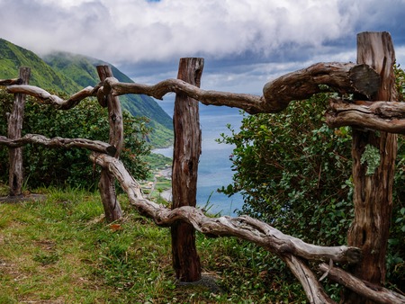 Image of wodden fence in front of a cliff with coast and sea in the backgroundの写真素材