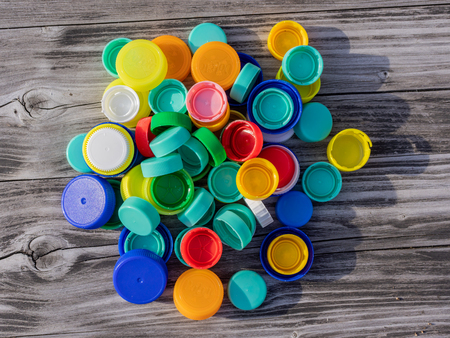 Image of colorful plastic caps on a wooden tableの写真素材
