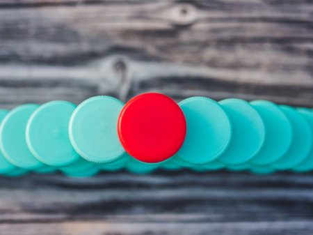 Image of different colored plastic caps on wooden background, creative conceptの写真素材