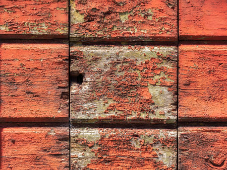 Close up image of red weathered color on a wooden plank