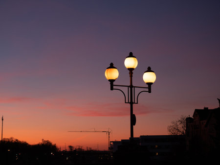 Image of three illuminated street lanterns during sunset, close up