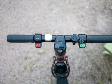 Close up image of an e-scooter handlebar with breaks, acceleration and a bellの写真素材