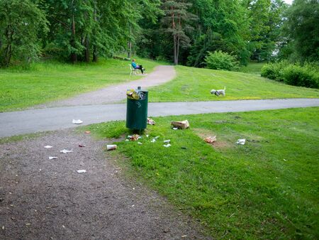 Helsinki, Finland- June 11, 2019: Waste next to trash bin in a park in Helsinkiのeditorial素材